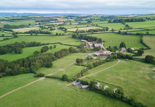 Luchtfoto van groene velden en gebouwen bij BoerenBed Billingsmoor Farm in Zuidwest-Engeland, Verenigd Koninkrijk.