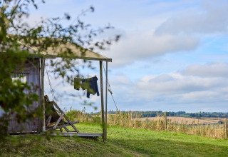 Zelt auf dem BoerenBed Billingsmoor Farm Ferienpark mit Blick auf die Landschaft und Wäsche auf der Leine.