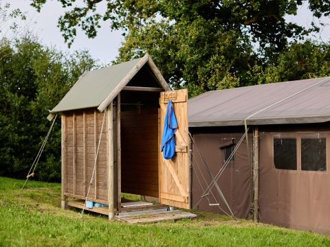 Außendusche und Zelt bei BoerenBed Billingsmoor Farm, Ferienpark in Südwestengland, Vereinigtes Königreich.