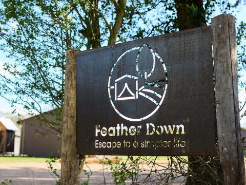 Bord bij BoerenBed Foxglove Farm vakantiepark in Zuidoost-Engeland met Feather Down-logo en slogan.