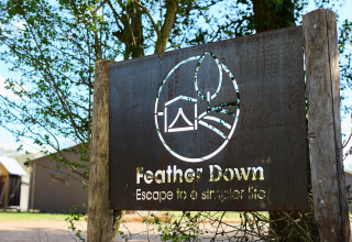 Bord bij BoerenBed Foxglove Farm vakantiepark in Zuidoost-Engeland met Feather Down-logo en slogan.