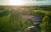 Luftaufnahme vom BoerenBed Foxglove Farm Ferienpark in Südostengland mit grünen Feldern und Hütten.