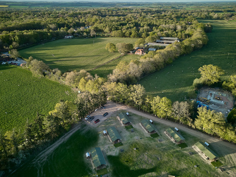 Luchtfoto van het vakantiepark BoerenBed Foxglove farm in Zuidoost-Engeland, omgeven door groene velden.
