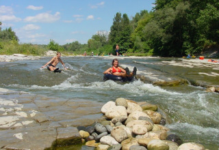 Bambini si divertono sul fiume con ciambelle gonfiabili al campeggio La Digue, Alvernia-Rodano-Alpi, Francia.