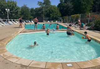 Famiglie si rilassano e nuotano nella piscina del campeggio La Digue in Auvergne-Rhône-Alpes, Francia.