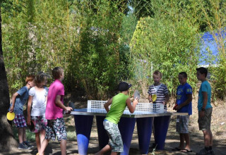Bambini giocano a ping pong all'aperto al campeggio La Digue in Auvergne-Rhône-Alpes, Francia.
