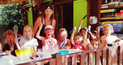 Bambini e un adulto partecipano a un laboratorio di cucina al Campeggio La Digue in Alvernia-Rodano-Alpi, Francia.