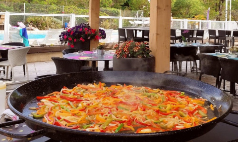 Grande padella che cucina verdure al ristorante all'aperto del camping La Digue, Auvergne-Rhône-Alpes, Francia.
