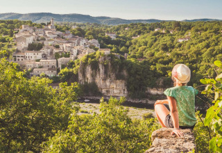 Persona che ammira un pittoresco villaggio collinare immerso nel verde presso La Digue, Alvernia-Rodano-Alpi.