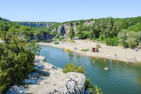 Spiaggia fluviale presso il campeggio La Digue, parco vacanze in Auvergne-Rhône-Alpes, Francia, immerso nel verde.