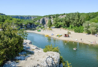 Spiaggia fluviale presso il campeggio La Digue, parco vacanze in Auvergne-Rhône-Alpes, Francia, immerso nel verde.