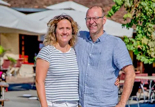 Coppia sorridente all'aperto presso Camping Les Terrasses de Dordogne, parco vacanze in Nouvelle-Aquitaine, Francia.