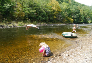 Bambini giocano vicino al fiume al campeggio Les Terrasses de Dordogne in Nouvelle-Aquitaine, Francia.