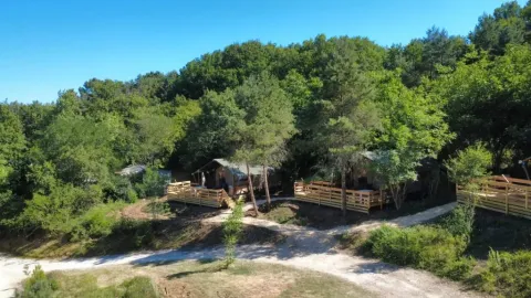 Tende safari al campeggio Les Terrasses de Dordogne immerse tra gli alberi in Nouvelle-Aquitaine, Francia.