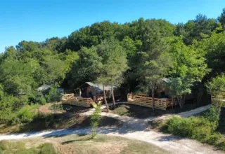 Tende safari al campeggio Les Terrasses de Dordogne immerse tra gli alberi in Nouvelle-Aquitaine, Francia.