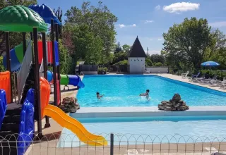 Area giochi e piscina del campeggio Les Terrasses de Dordogne, villaggio vacanze in Nouvelle-Aquitaine, Francia.