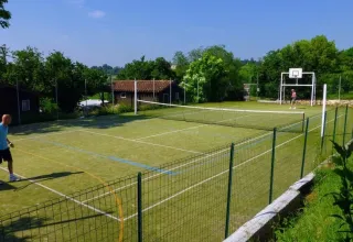 Campo multisport con rete da tennis e canestro presso Les Terrasses de Dordogne, villaggio vacanze in Francia.