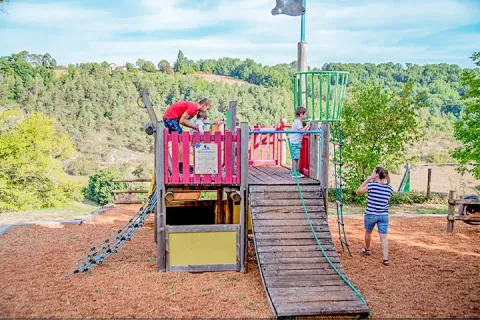 Parco giochi con bambini e adulti al campeggio Les Terrasses de Dordogne, villaggio vacanze in Nouvelle-Aquitaine, Francia.