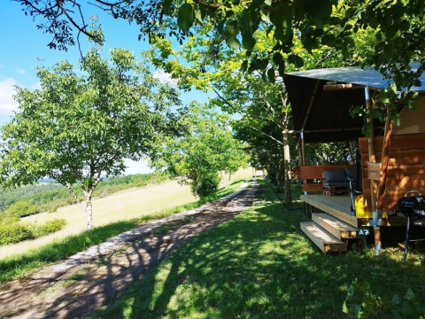 Tente safari Lodgetent avec salle de bain au camping Les Terrasses de Dordogne, entourée par la nature en France.