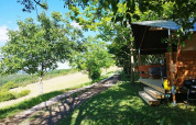 Tente safari Lodgetent avec salle de bain au camping Les Terrasses de Dordogne, entourée par la nature en France.