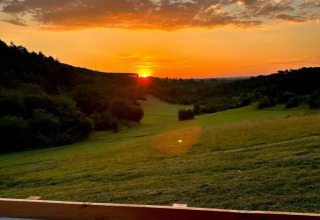 Vue du coucher de soleil depuis une Lodgetent met badkamer au camping Les Terrasses de Dordogne en France.