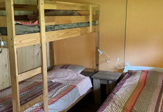 Das Foto zeigt den Schlafbereich eines Safarizeltes mit Badezimmer, mit Etagenbett und Einzelbett.