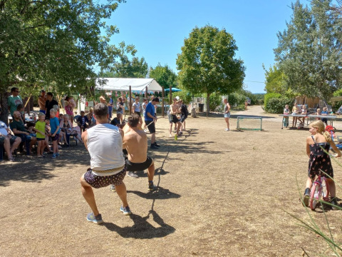 Adulti e bambini partecipano a una gara di tiro alla fune al campeggio Camp Redon, Occitania, Francia.