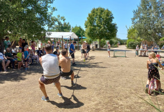 Adulti e bambini partecipano a una gara di tiro alla fune al campeggio Camp Redon, Occitania, Francia.