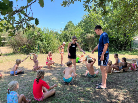Bambini giocano all'aperto al sole al campeggio Camp Redon, un villaggio vacanze in Occitania, Francia.