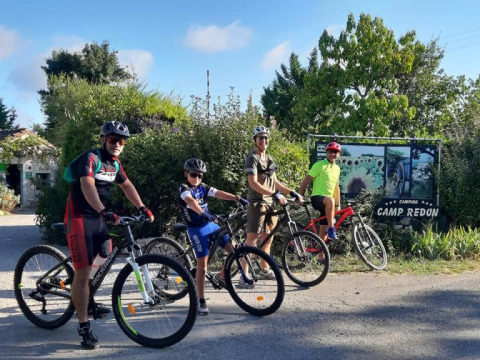 Quattro ciclisti pronti a partire davanti al Camping Camp Redon, parco vacanze in Occitania, Francia.