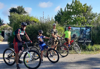 Quattro ciclisti pronti a partire davanti al Camping Camp Redon, parco vacanze in Occitania, Francia.