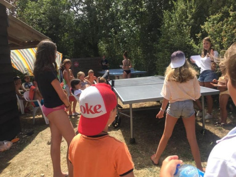 Bambini giocano a ping pong all'aperto presso il campeggio Camp Redon, in Occitania, Francia.