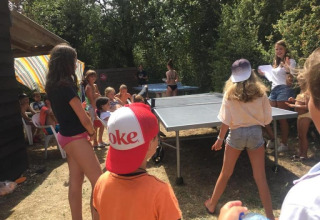 Bambini giocano a ping pong all'aperto presso il campeggio Camp Redon, in Occitania, Francia.