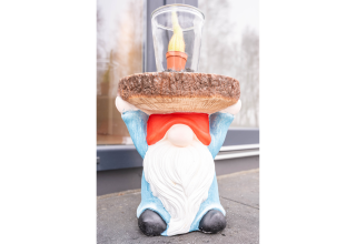 Statua da giardino di gnomo con cappello rosso che regge un vassoio e candela a Villa BushBush, De Kremmer, Paesi Bassi.
