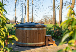 Bañera de hidromasaje de madera al aire libre con tapa y escalones en Weideblik met hottub, Holiday center 't Schuttenbelt.