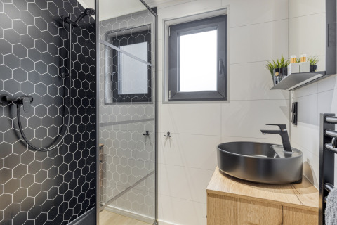 Moderne badeværelse på Weideblik met hottub, Holiday center 't Schuttenbelt, med sort brus og håndvask.