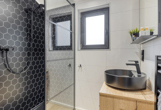 Modernes Badezimmer im Weideblik met hottub, Holiday center 't Schuttenbelt, mit schwarzer Dusche und Waschbecken.