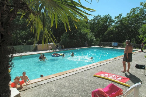 Persone che si godono una giornata di sole in piscina al campeggio Le Moulin de Cost in Auvergne-Rhône-Alpes.