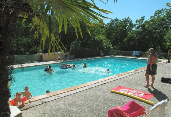 Persone che si godono una giornata di sole in piscina al campeggio Le Moulin de Cost in Auvergne-Rhône-Alpes.