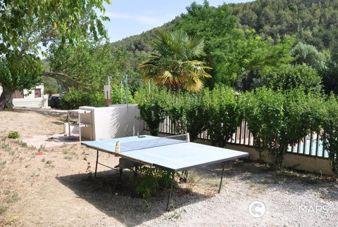 Tavolo da ping pong all'aperto al campeggio Le Moulin de Cost, circondato dal verde in Francia.