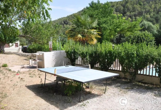 Tavolo da ping pong all'aperto al campeggio Le Moulin de Cost, circondato dal verde in Francia.