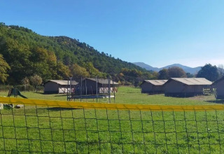 Vista di tende e colline verdi al campeggio Le Moulin de Cost, Auvergne-Rhône-Alpes, Francia in una giornata di sole