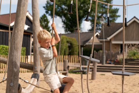 Junge spielt auf dem Spielplatz im Eco Boslodge Jacuzzi, Estate De IJsvogel, Niederlande, Sommer.