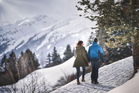 Couple marchant dans un paysage enneigé près de Pettneu am Arlberg, Tyrol, Autriche, entouré de montagnes.