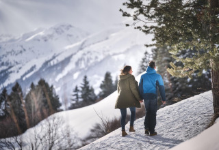 Couple marchant dans un paysage enneigé près de Pettneu am Arlberg, Tyrol, Autriche, entouré de montagnes.