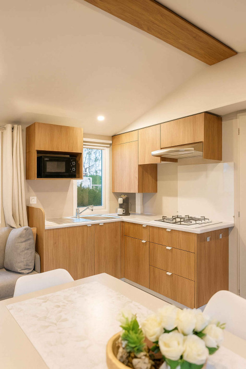 Cucina moderna in legno con fornello a gas e tavolo da pranzo al Vakantiehuis Celestia, Camping Papillon.