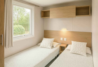 Camera moderna con due letti singoli, mobili in legno e finestra al Vakantiehuis Celestia, Camping Papillon.