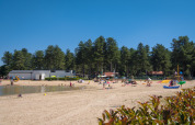 Kindvriendelijk zandstrand met speeltuin in Arden Parks Tulderheyde, omgeven door bos in Antwerpen.