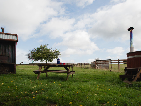 Picknicktafel op het gras bij BoerenBed Hollings Hill, West Midlands, met hekwerk en landelijke sfeer.