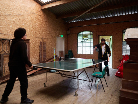 Due persone giocano a ping pong al coperto al BoerenBed Layer Marney Tower, parco vacanze nell'Est dell'Inghilterra.